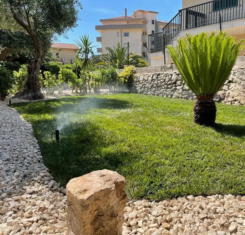 Tecnico verifica impianto di microirrigazione per piante sensibili.